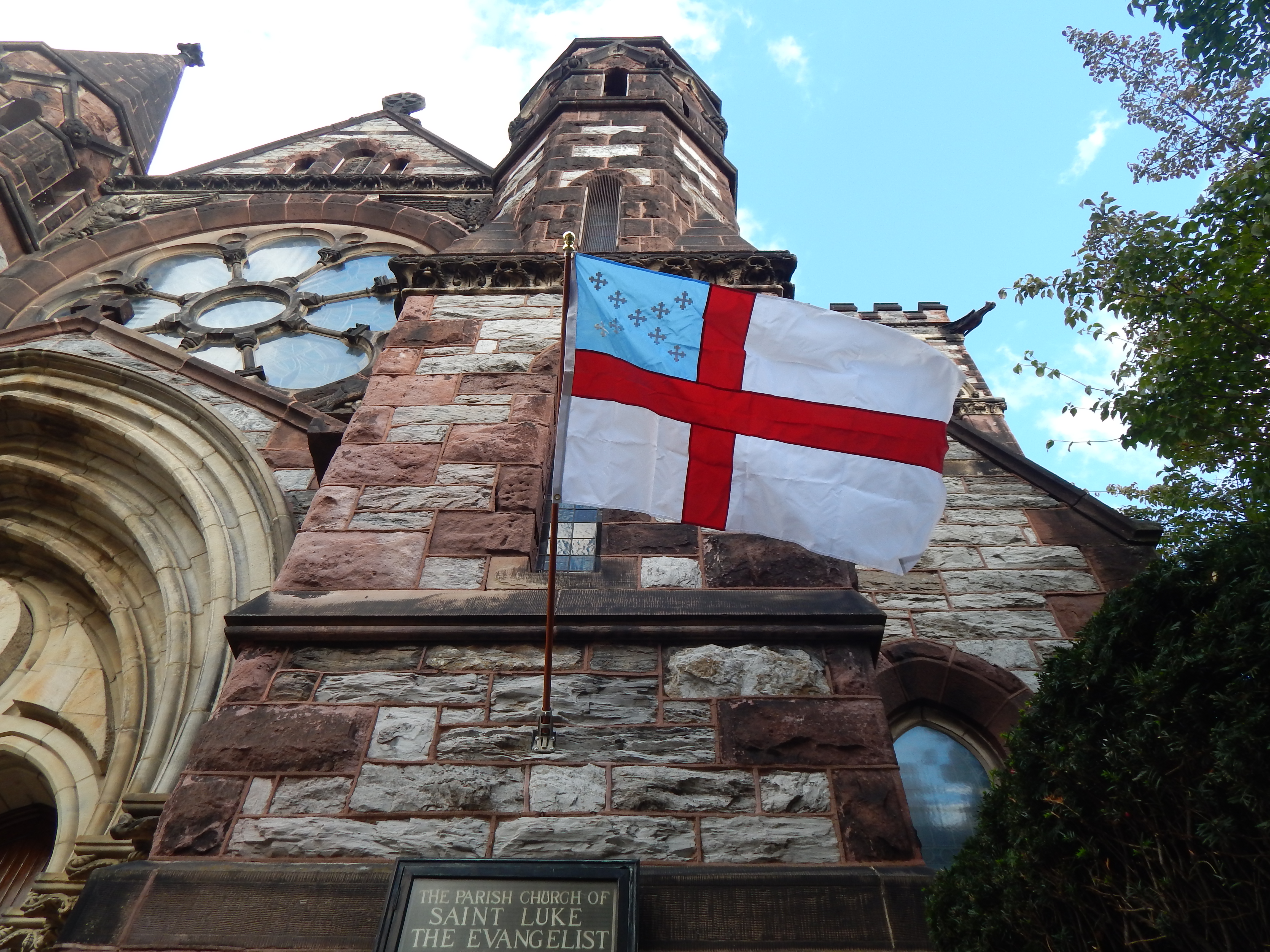 exterior of a stone church with Episcopal Church flag