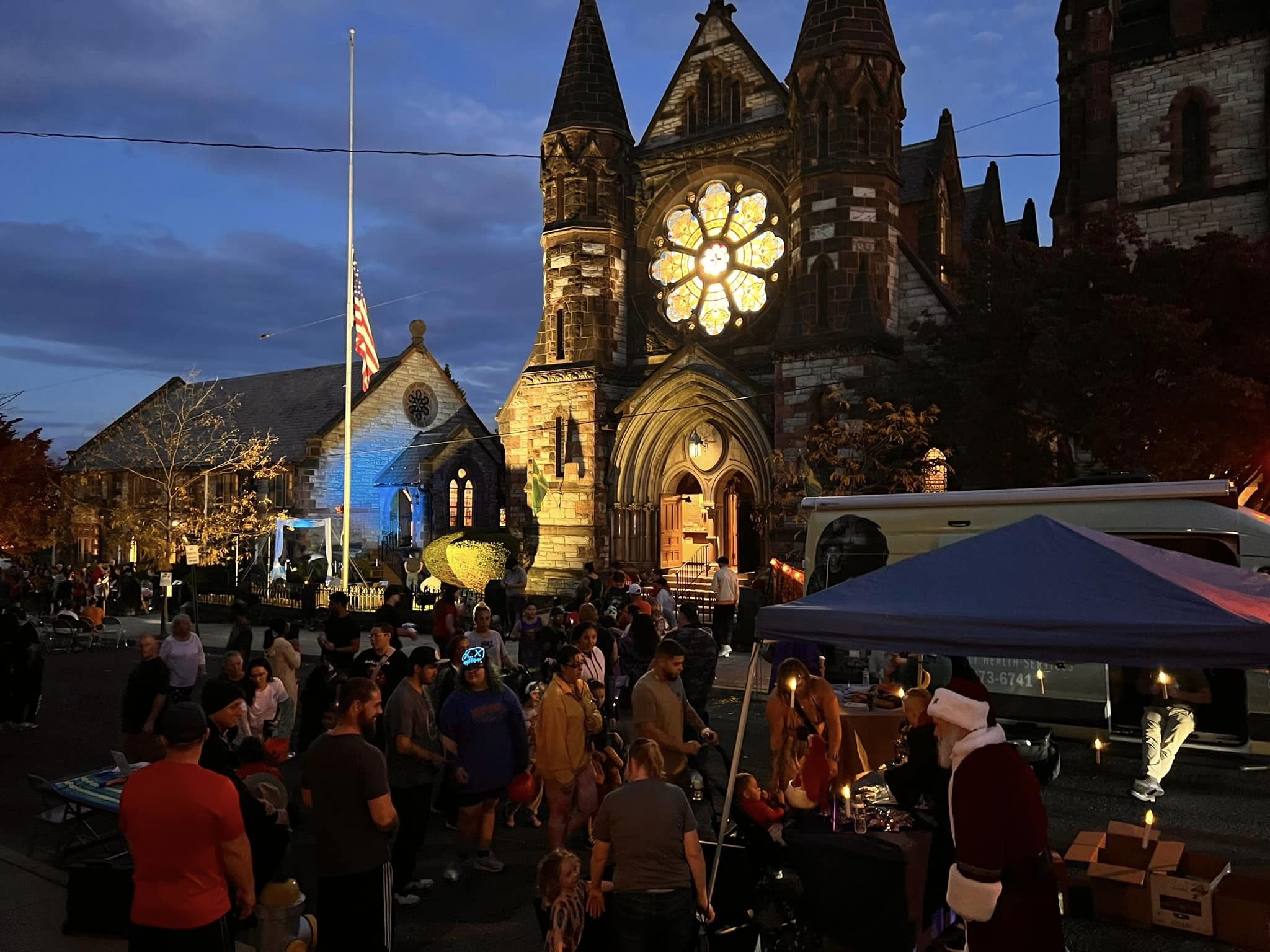exterior of a church at night with a crowd in the foreground