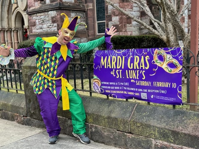 jester in front of church with mardi gras sign